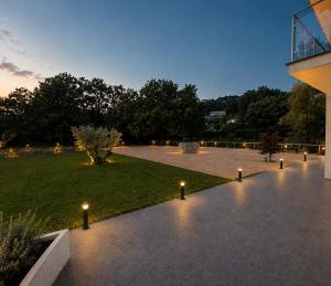 a courtyard with lights and a grass field at The Queen Oak - nature relais in Santa Marina