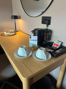 a wooden table with two cups and a coffee maker at The Brewhouse Hotel in Edinburgh
