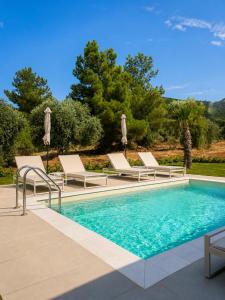 a swimming pool with lounge chairs and a swimming pool at Minimal Suites in Skala Rachoniou