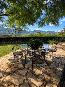 a patio with two chairs and a table with a potted plant at Oratório Pousada Boutique in Tiradentes
