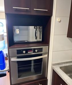 a microwave oven sitting inside of a kitchen at Departamento en Calama in Calama +4 photos