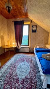 a bedroom with a bed and a window and a rug at На Видземском взморье Калнгале in Kalngale