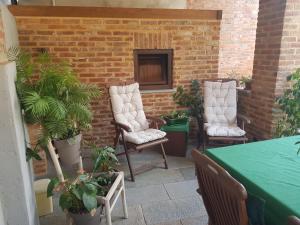 a patio with two chairs and a table and some plants at Mirtillo & Margot in Cambiano