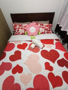 two stuffed animals sitting on a bed with hearts at Shore residences tower D in Manila +10 photos