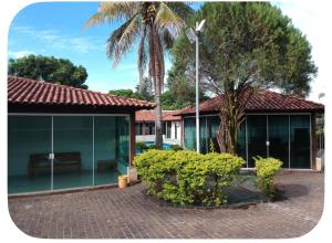 a building with a palm tree in front of it at suítes Arco-íris in Uberlândia