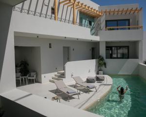 a person standing in a swimming pool in a house at Anapollo Boutique Hotel Adults Only in Naxos Chora