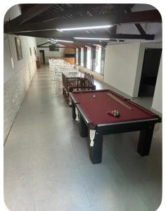 a pool table in a room with tables and chairs at suítes Arco-íris in Uberlândia