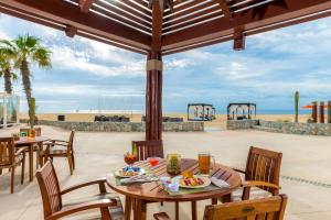 a patio with tables and chairs and a view of the beach at Pueblo Bonito Pacifica Golf & Spa Resort - All Inclusive - Adults Only in Cabo San Lucas