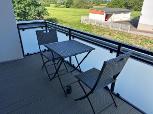 a balcony with two chairs and a table on a deck at Thiels Mansion in Sankt Sebastian
