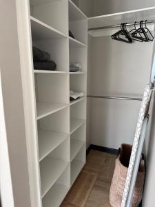 a walk in closet with white shelves and a ladder at The Precinct Lifestyle in Midrand +7 photos