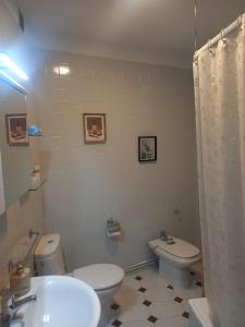 a bathroom with a white toilet and a sink at Puerto de Burela in Burela de Cabo +23 photos