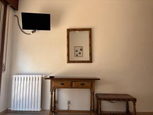 a mirror on a wall with a wooden table and a television at Pensión Las Arenas in Vilagarcia de Arousa +14 photos