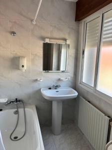 a bathroom with a sink and a mirror and a tub at Pensión Las Arenas in Vilagarcia de Arousa