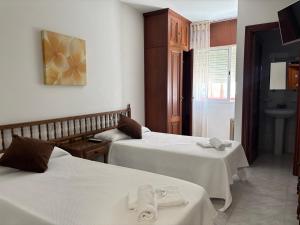 a hotel room with two beds and a sink at Pensión Las Arenas in Vilagarcia de Arousa