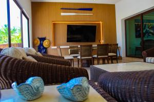 a living room with couches and a flat screen tv at Villa Siros de 4 habitaciones in Chicxulub