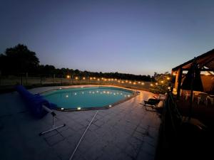 a swimming pool at night with lights around it at Gite d'Aimelles in Billezois