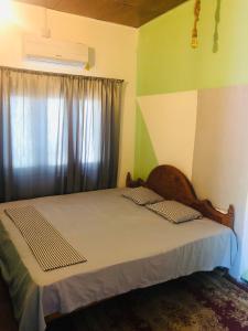 a bedroom with a large bed with a window at Trio Mango Stay in Arugam Bay