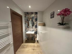 a bathroom with a sink and a vase of flowers at Apartamentos Rurales La Estrella in Casar de Palomero