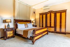 a bedroom with a large wooden bed and a nightstand at Moriah Hill Resort in Kibuye +13 photos