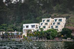 a large white building on the shore of a body of water at Moriah Hill Resort in Kibuye
