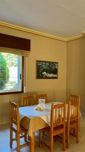 a dining room with a table and chairs and a window at Pension As Termas in Bubaces
