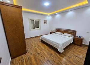 a bedroom with a bed and a wooden floor at فيلا في كينج مريوط in Alexandria