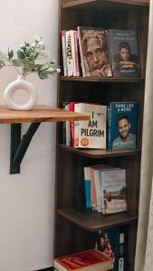 a book shelf with books and a vase of flowers at Udaya Hotel in Kovalam