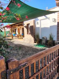 a wooden fence in front of a house with a green roof at Crisol. in Cafayate