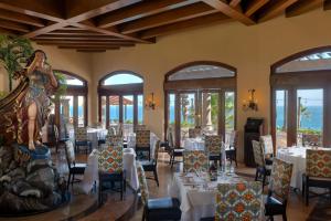 a dining room with white tables and chairs at Pueblo Bonito Sunset Beach Golf & Spa Resort - All Inclusive in Cabo San Lucas