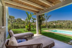 an outdoor patio with a couch and a pool at Cala Sinzias Resort in Castiadas