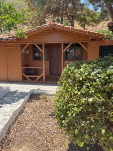 a small house with a porch and some bushes at Adrasan blue bay hotel in Kumluca