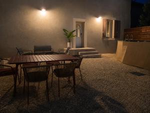 a patio with a table and chairs at night at Le Mas d'Elio in Cheval-Blanc