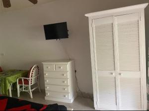 a bedroom with a bed and a dresser and a television at Pondbottom Apartments Hotel in Saint James