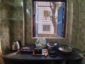 a counter top with pots and pans and a window at Comfort Studio Type Appartment - Kolkata in Nager Bazaar