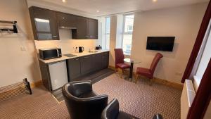 a kitchen with black cabinets and a table and chairs at Crystal House in Barmouth