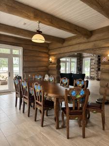 a dining room with a wooden table and chairs at Private lakeside holiday house with fireplace, sauna, hot tub - Ezernams Dzintars in Valdemārpils