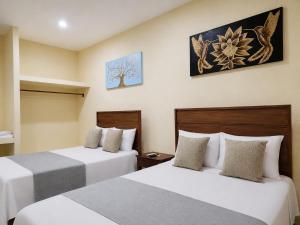 a hotel room with two beds in a room at Habitaciones Huitzilin in Brisas de Zicatela