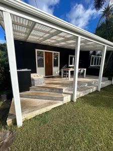 a wooden deck with a white pergola at Oneroa Manuka Residence in Waiheke Island