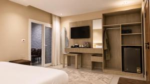 a bedroom with a bed and a desk and a tv at Dar Pyramids Boutique in Cairo