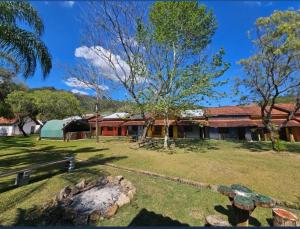 a house with a large yard with a tree at Rancho Maria Pimenta in Joanópolis