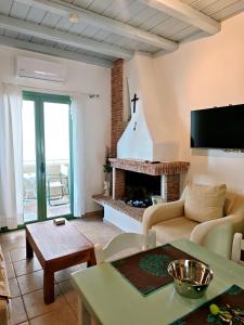 a living room with a couch and a fireplace at MONI apartment in Perdika