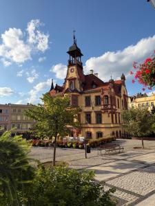 a large building with a tower on top of it at Apartament Piastów 12 in Nowa Ruda