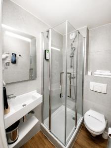 a bathroom with a shower and a toilet and a sink at Kyriad Hôtel La Fleche in La Flèche +45 photos