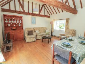a living room with a table and a couch at Byre Cottage 3 in Pulborough