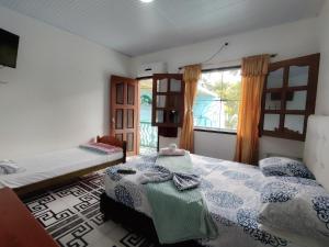 a bedroom with two beds and a window at Hotel Alto Amazonas in Leticia