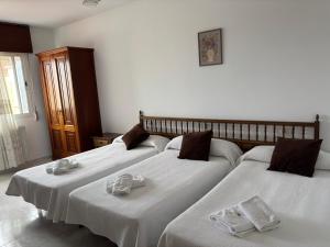 a group of three beds in a room at Pensión Las Arenas in Vilagarcia de Arousa