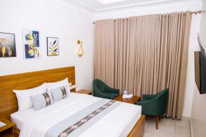 a hotel room with a bed and two chairs at Velvet Suites in Kigali +134 photos