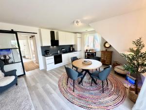 a living room with a table and chairs at Vollmöblierte hochwertige neue Apartments in Klevendeich