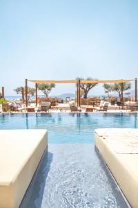 a swimming pool with two beds in a resort at Glaronissi Beach in Plaka
