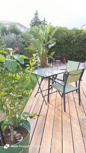 a table and chairs sitting on a wooden deck at Chambre climatisée indépendante 300m mer in Six-Fours-les-Plages